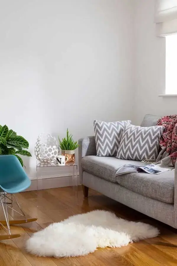 decoração simples para sala com sofá cinza e mesa de canto pequena de acrílico Foto Architonic