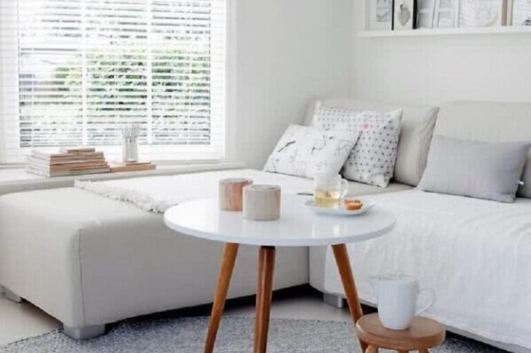sala branca decorada com tapete de crochê cinza e mesa de centro redonad para sala Foto Archzine