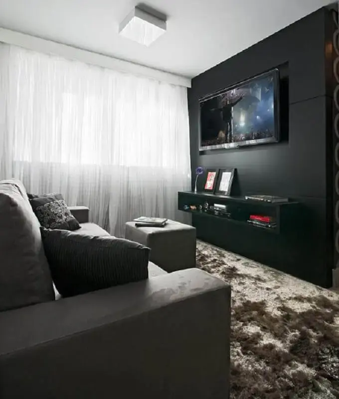 sala com parede preta decorada com tapete felpudo e sofá cinza Foto Pinterest