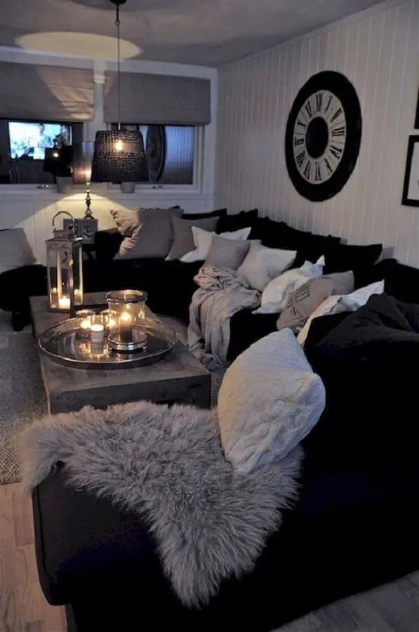 sala com sofá preto decorada com várias almofadas Foto Pinterest