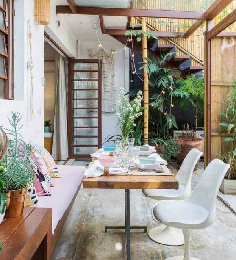 varanda decorada com cadeiras brancas e mesa com banco estofado Foto Histórias de Casa