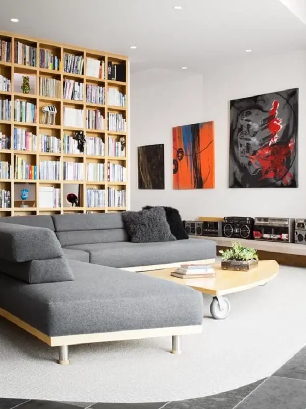 A base em madeira deixa o sofá de canto cinza mais moderno