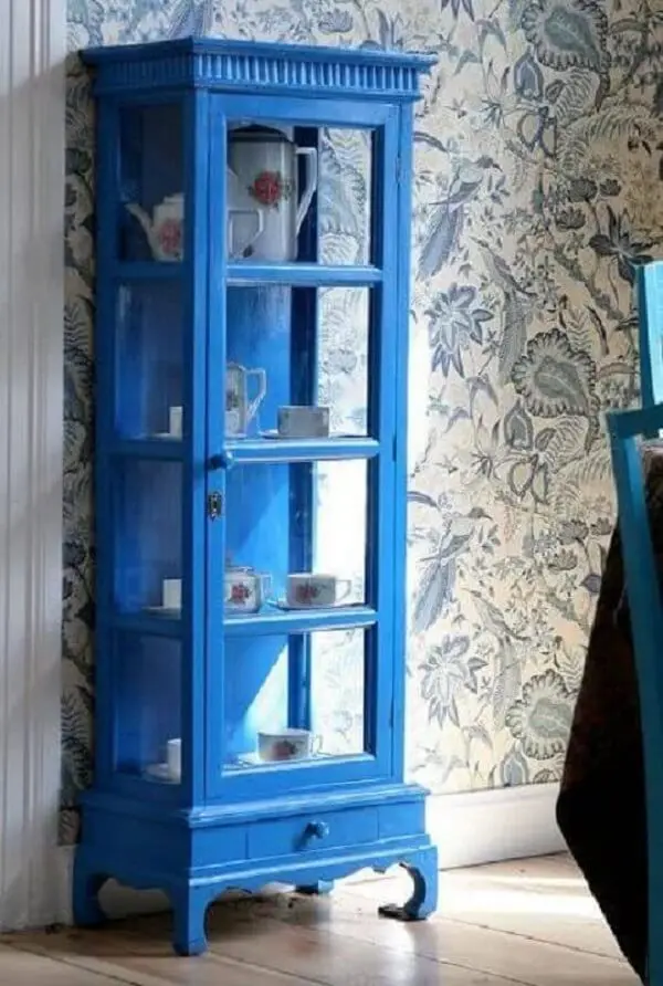 A cristaleira de madeira azul se destaca na decoração