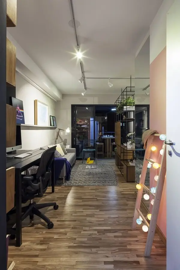 A luminária trilho auxilia na iluminação do home Office e da sala de estar integrada