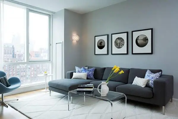 A sala com sofá de canto cinza pode ficar ainda mais bonita com a iluminação natural da janela