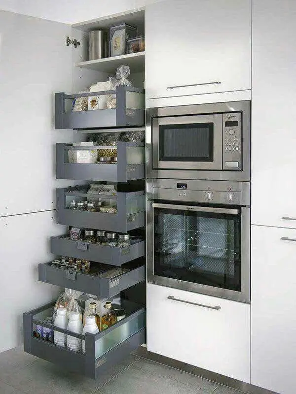 O armário para despensa de cozinha fica ao lado dos eletrodomésticos do espaço