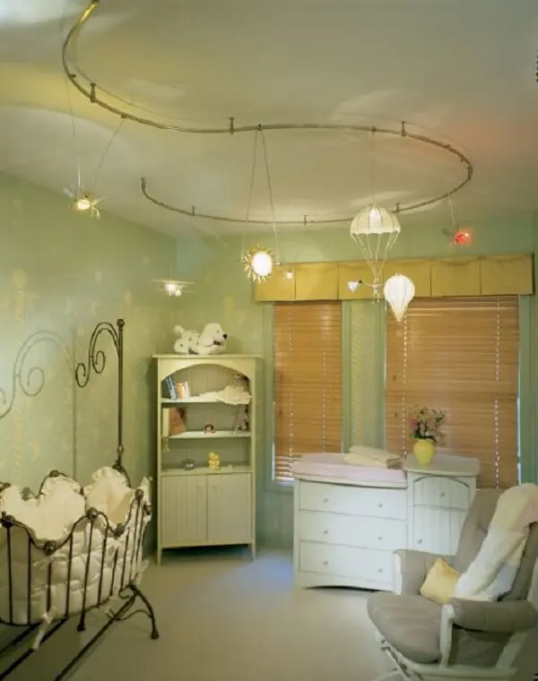 O modelo de luminária spot trilho se encaixa graciosamente na decoração provençal do quarto do bebê