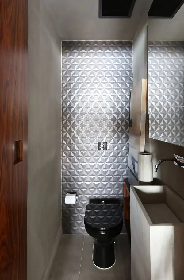 O revestimento 3D para banheiro pequeno metalizado é o grande destaque desse espaço