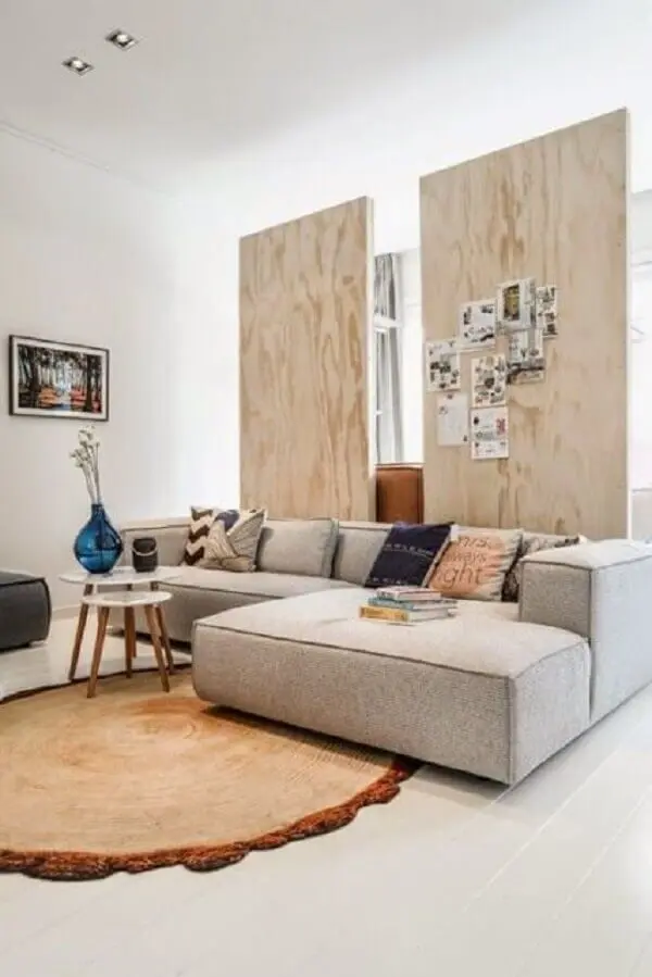 O sofá de canto cinza com chaise complementa a decoração da sala