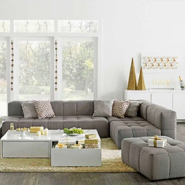 O sofá de canto cinza delimita a área da sala