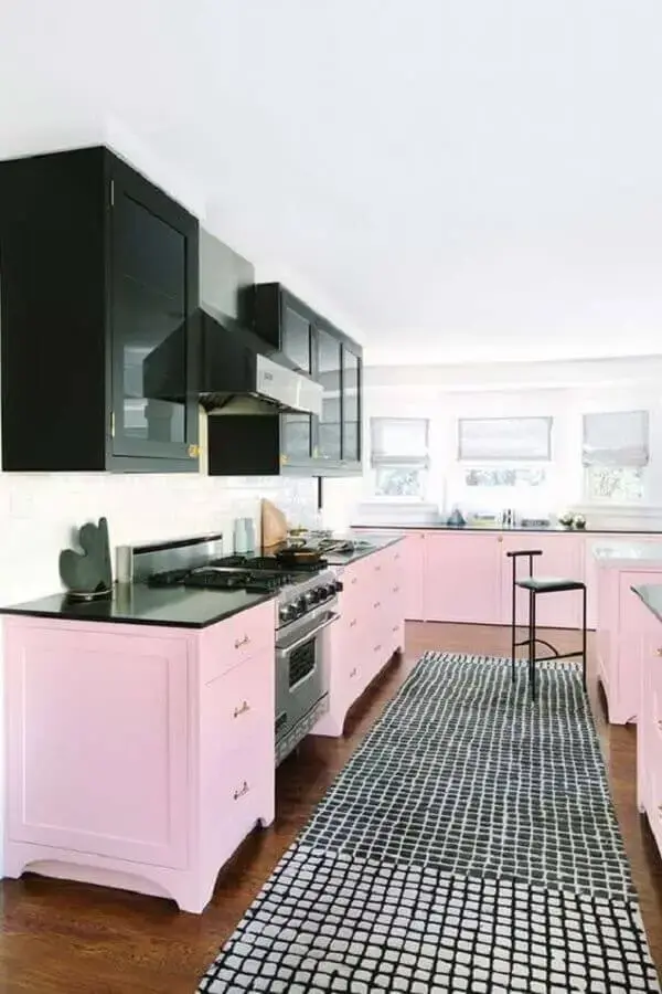 cozinha decorada com armário aéreo preto e armários cor de rosa chá Foto PureWow