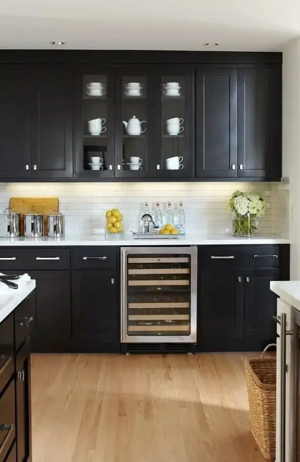 Cozinha com armário preto com portas de vidro