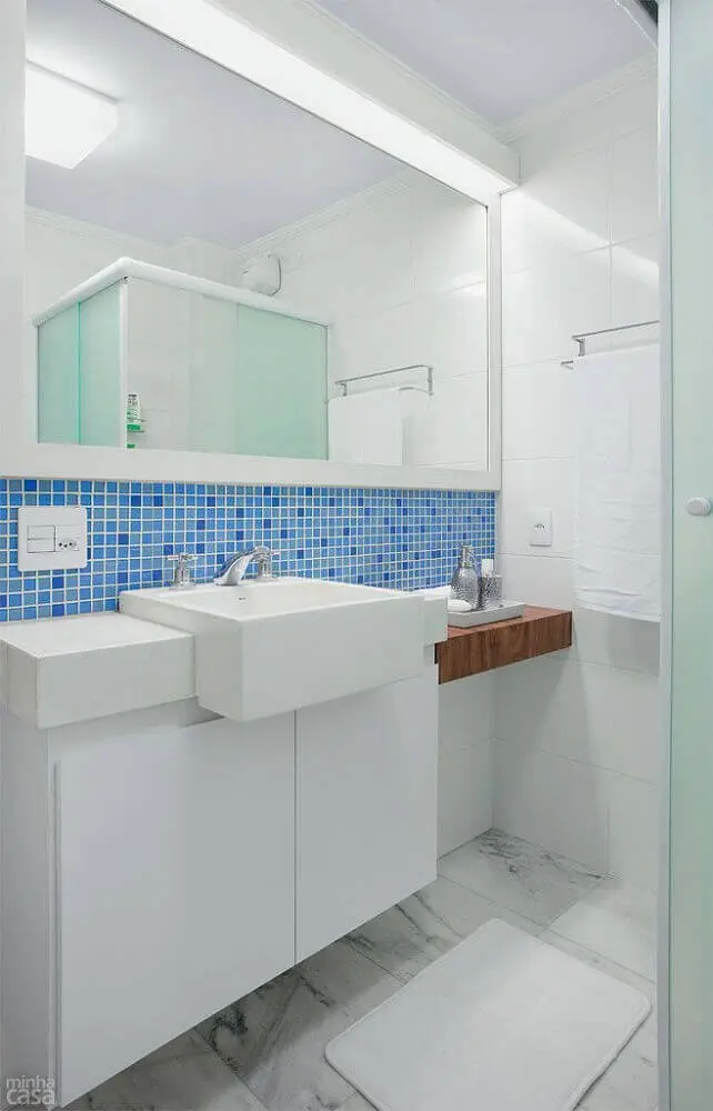 Decoração de banheiro com pastilha adesiva azul embaixo do espelho