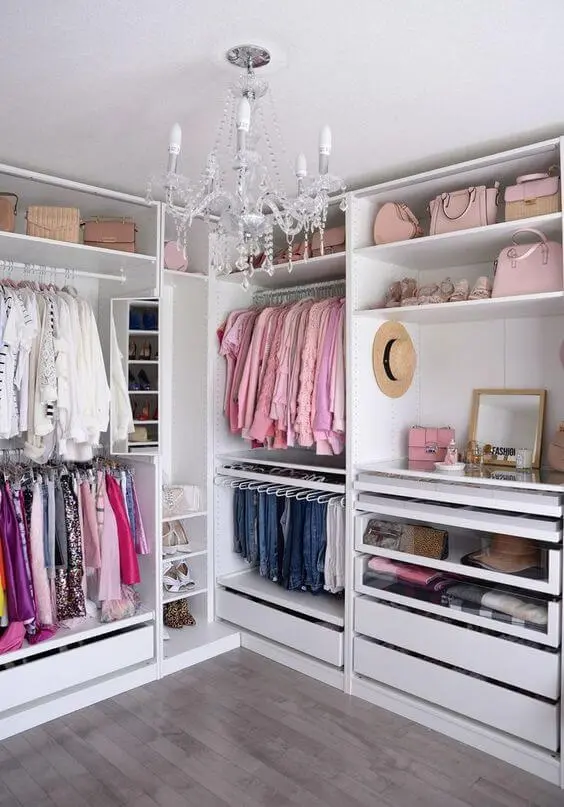 Guarda roupa de canto no closet moderno com lustre luxuoso
