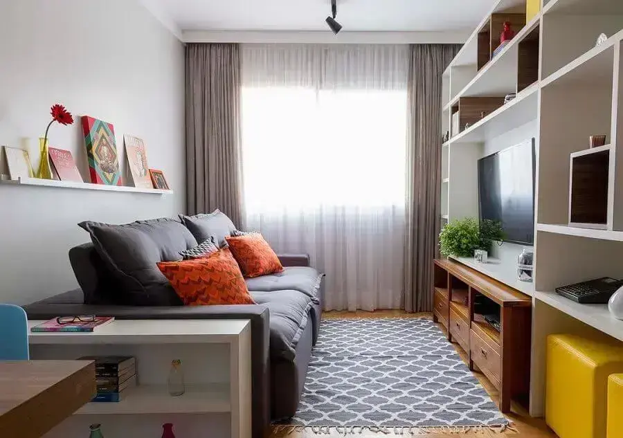 sala de apartamento pequeno decorado com estante de nichos planejada e sofá cinza Foto Arquitrecos