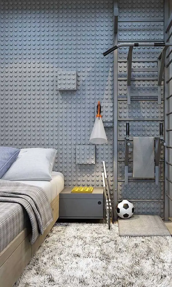 A cama de solteiro viúva se encaixa perfeitamente na decoração desse quarto com revestimento de Lego