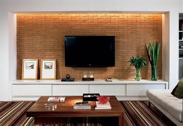 A moldura em madeira dos quadros para sala de TV trazem um toque rústica ao ambiente