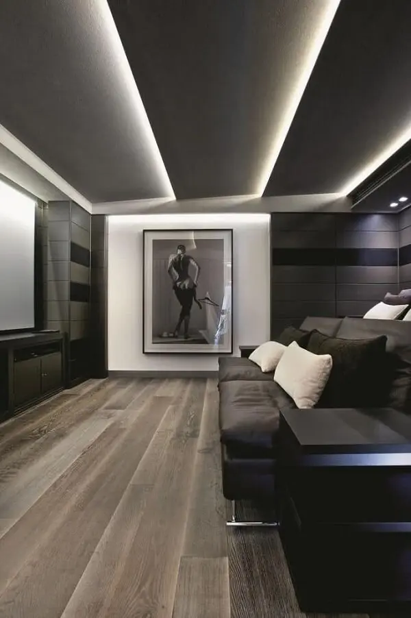 A sanca de gesso inclinada com iluminação embutida promove uma decoração aconchegante na sala com home theater