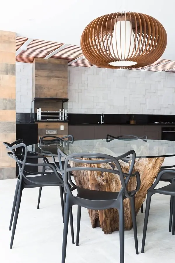 Mesa com tampo de vidro e cadeiras de plástico decoram a área gourmet rústica moderna