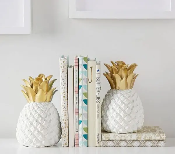 O abacaxi em cerâmica faz sucesso como aparador de livros