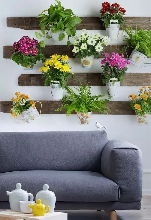 Para decorar a sala nada melhor do que flores e folhagens suspensas em uma linda floreira rústica de parede