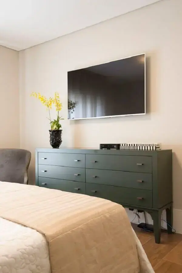 TV na parede do quarto com cômoda verde escura Foto Pinterest