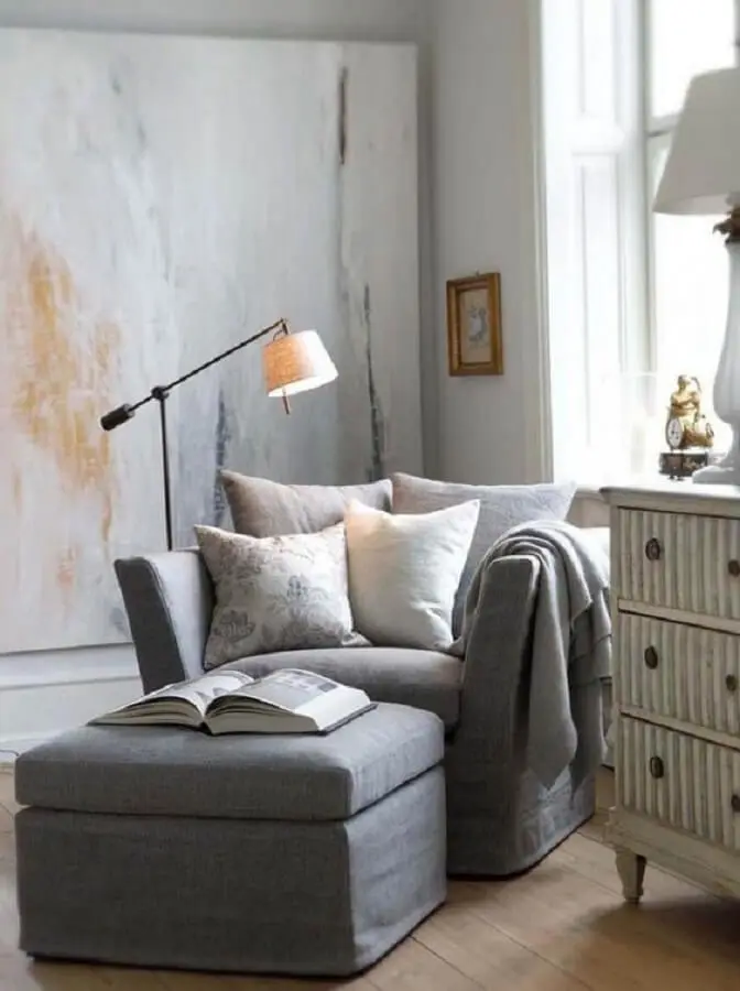 ambiente simples decorado com poltrona cinza confortável e luminária de chão para leitura Foto Fashionismo
