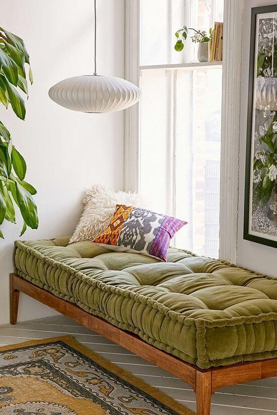 Banco de madeira com almofada futon verde confortável