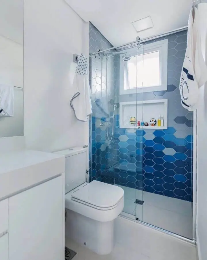 banheiro branco decorado com revestimento hexagonal azul na área do box  Foto SP Estúdio Arquitetura