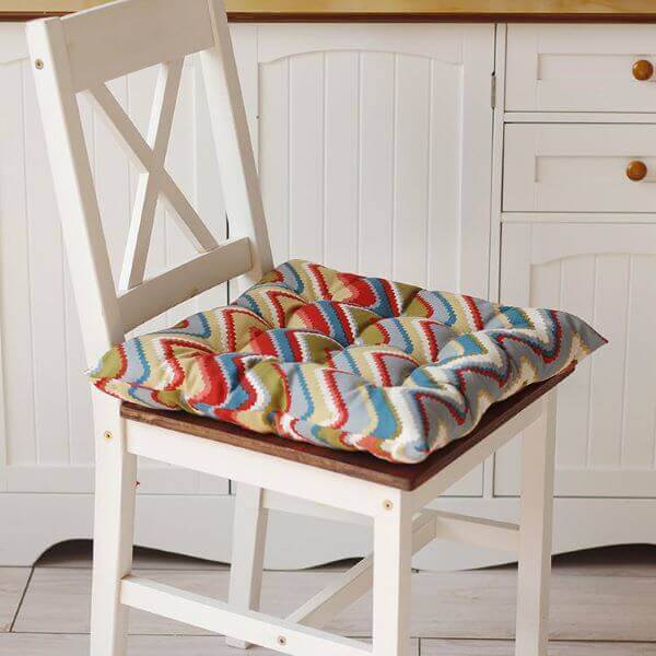 Cadeira branca com almofada futon colorida