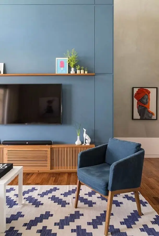decoração de sala com TV na parede azul e rack de madeira Foto Simplichique