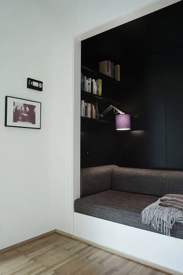 decoração moderna para cantinho de leitura com paredes pretas e luminária de parede para leitura Foto BusyBoo