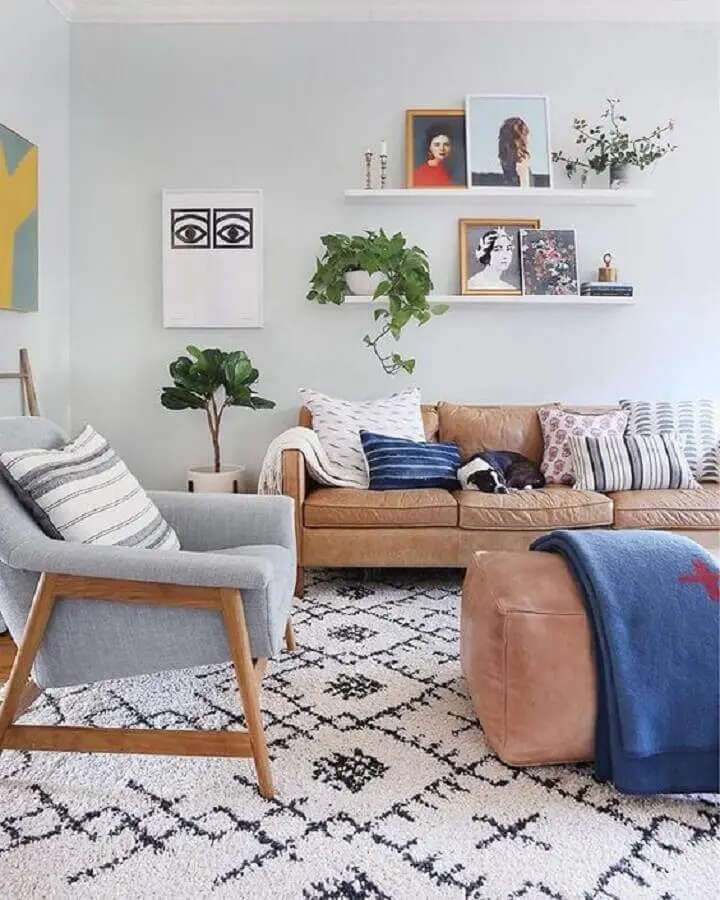 prateleira para quadros sala decorada com sofá marrom e poltrona de madeira Foto Sunny Circle Studio