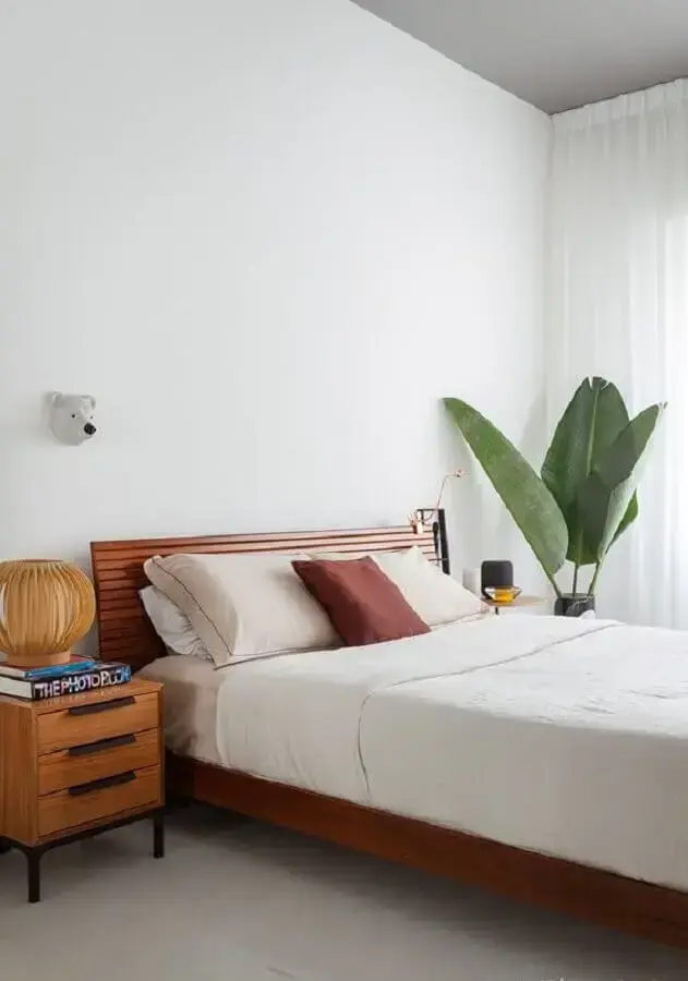 quarto simples decorado com parede branca e vaso de planta grande Foto Histórias de Casa