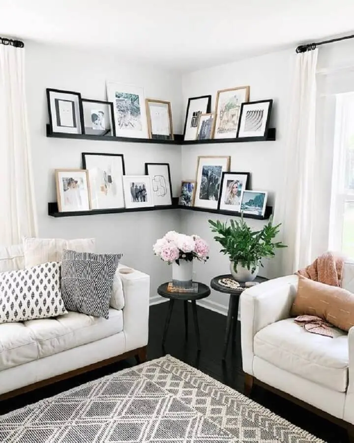 sala decorada com sofá branco e prateleira de canto para quadros Foto Pinterest