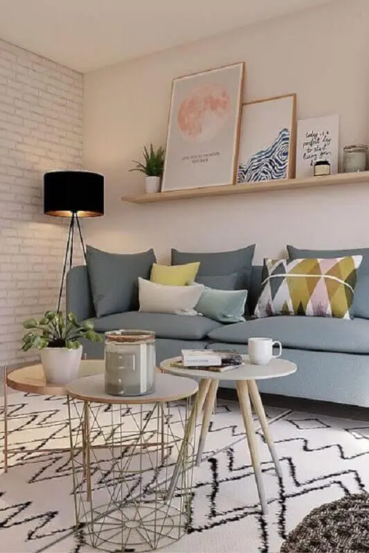 sala decorada com sofá cinza e prateleira para quadros de madeira Foto Jeito de Casa