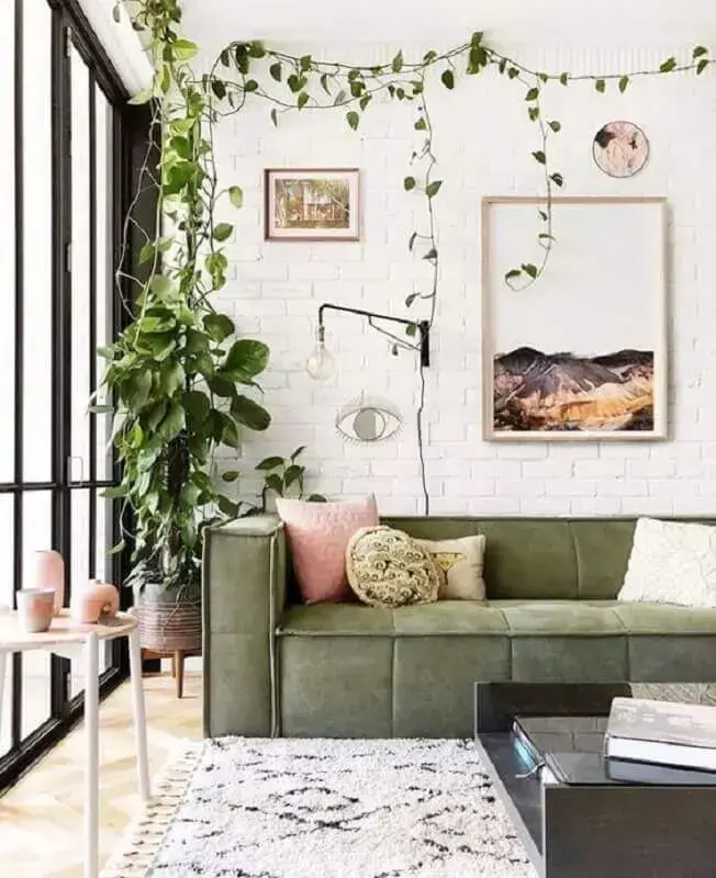 sala decorada com sofá verde e parede de tijolinho branco Foto Casa Très Chic