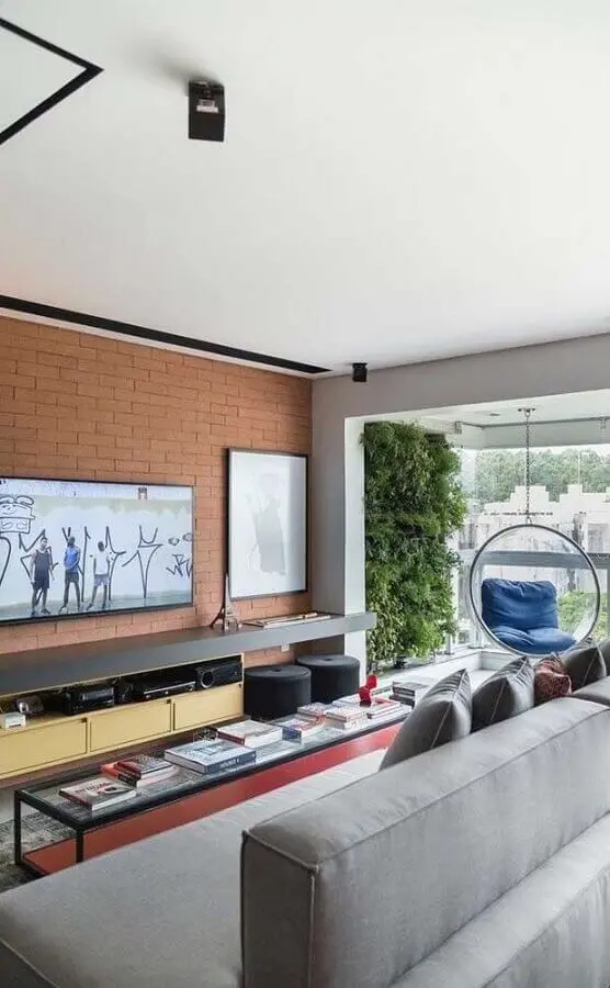 tv na parede de tijolinho à vista em sala moderna com sofá cinza Foto Futurist Architecture