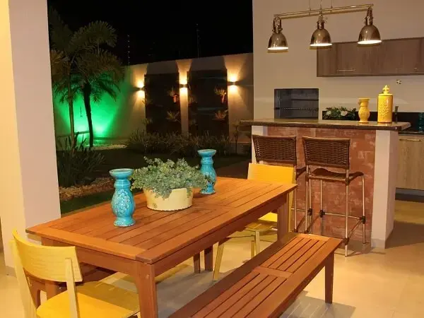 Área gourmet rústica simples com mesa e banco de madeira