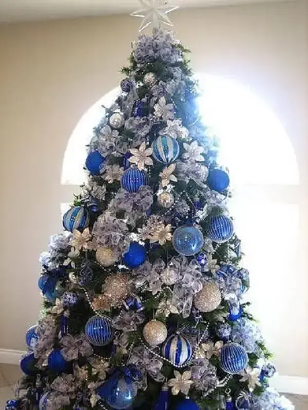 A majestosa árvore de natal azul e prata foi posicionada próxima a janela