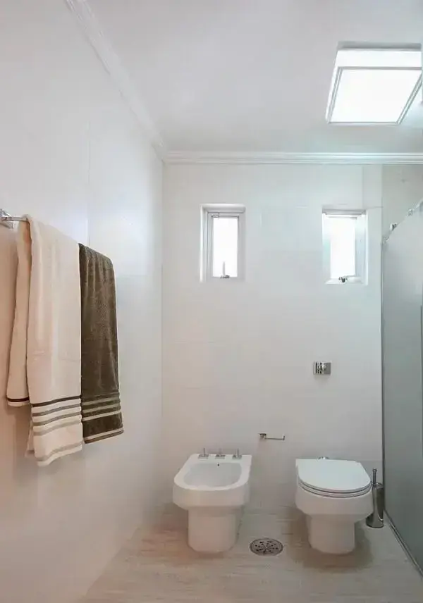 Banheiro com bidê branco complementa a decoração clean