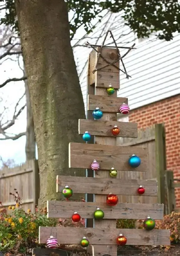Decoração de natal simples e barata para jardim feita com árvore de madeira e bolas coloridas
