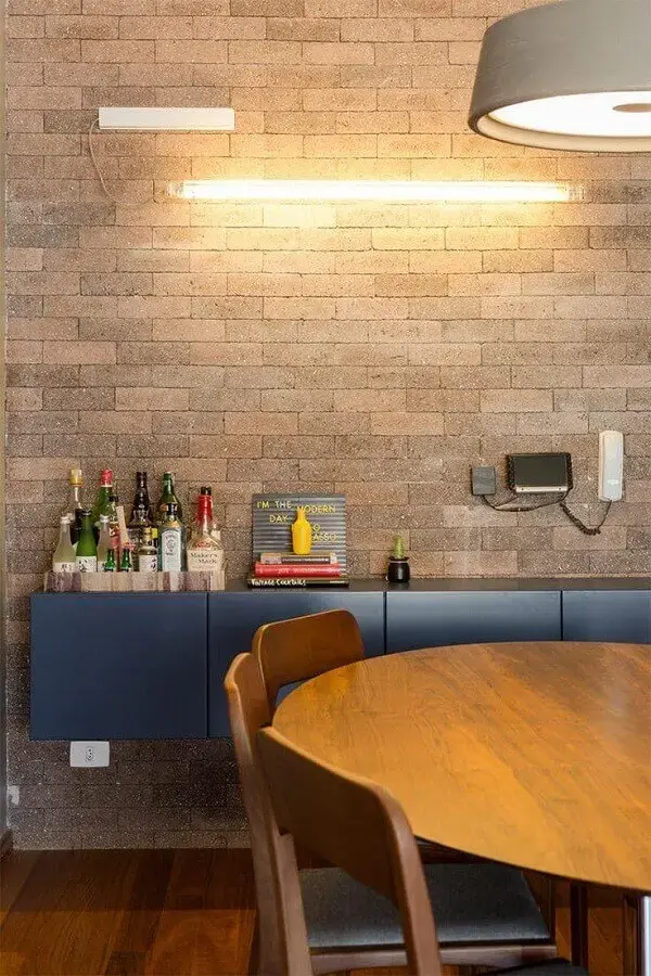 Decoração de sala de jantar com buffet aparador suspenso em parede de tijolinho à vista Foto DT Estúdio
