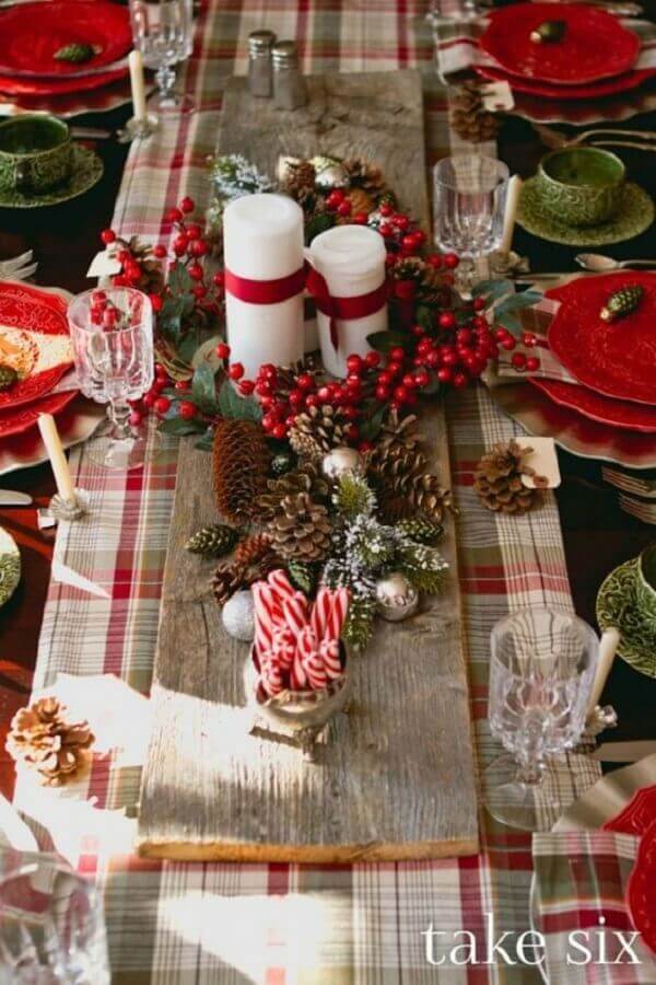 Ideia de enfeites de natal para mesa clássica com pinhas e velas Foto One Kindesign