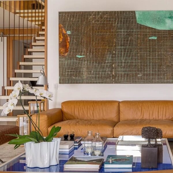 Tons terrosos: sala de estar com sofá clássico de couro marrom