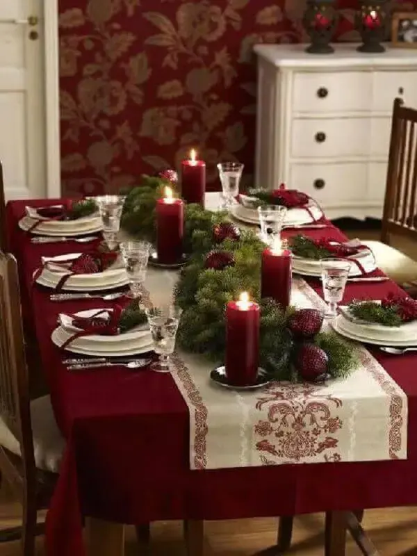 decoração de mesa natalina com festão verde e velas vermelhas Foto Chismes Today