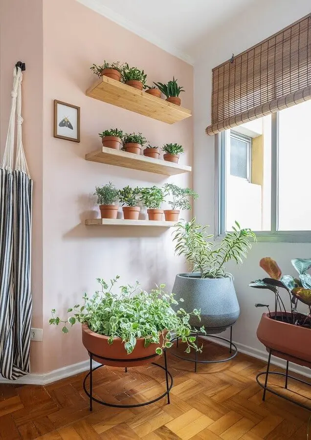 decoração de sala com parede rosa e prateleira de madeira para plantas Foto Histórias de Casa