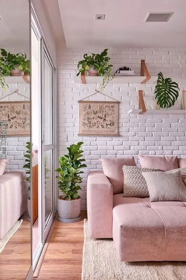 decoração de sala com sofá rosa e prateleira para plantas em parede de tijolinho branco Foto Casa de Valentina