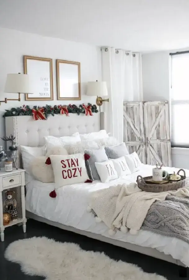 enfeites de Natal com festão para cabeceira de cama em quarto branco Foto The House of Sequins