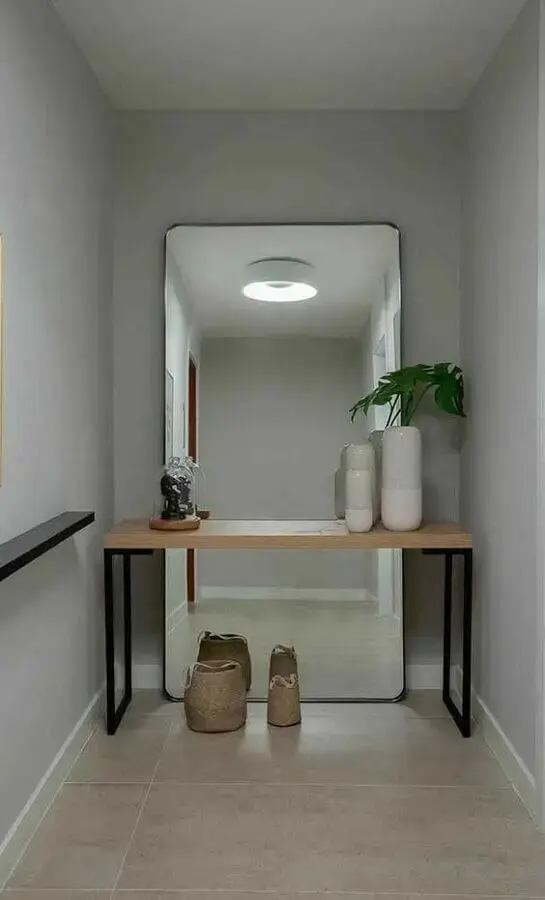 hall decorado com aparador moderno e espelho grande sem moldura apoiado no chão Foto Pinterest